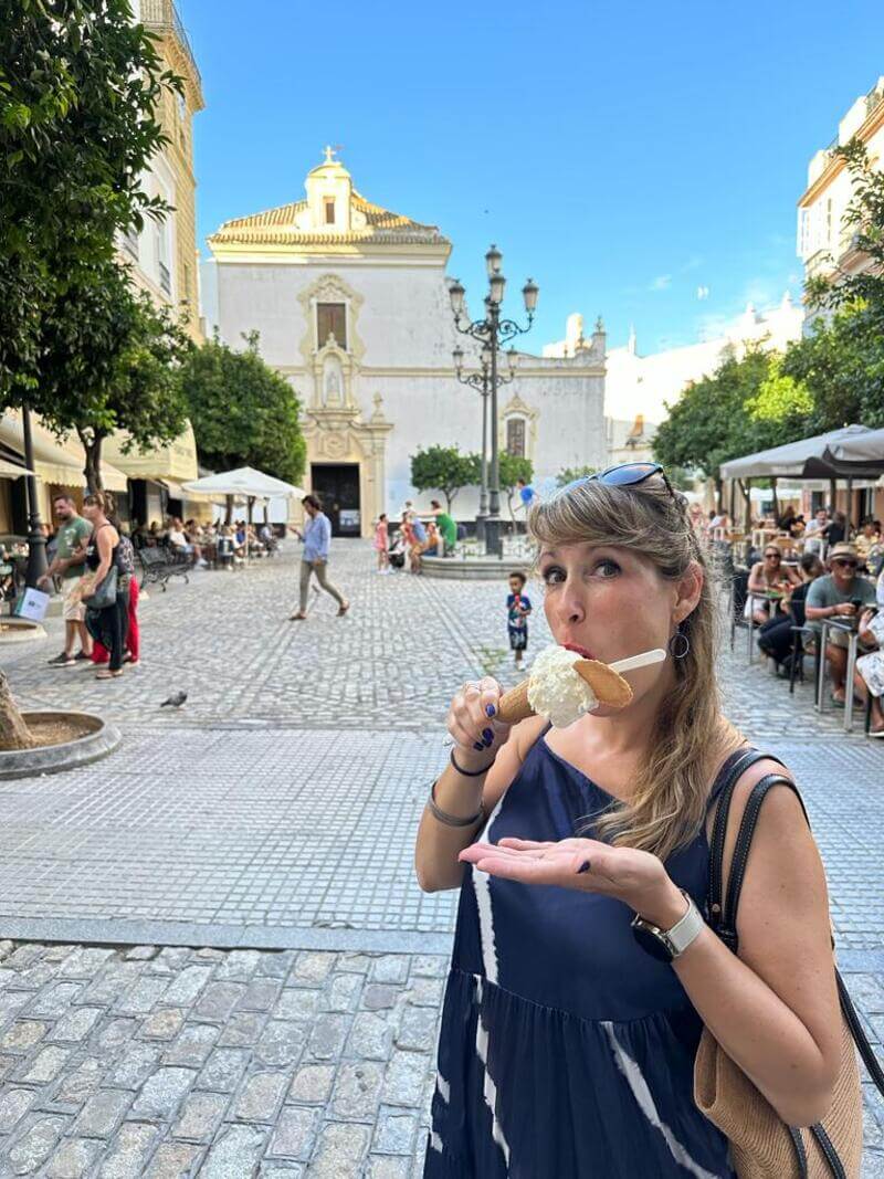 Woman enjoying ice cream in public square in Cadiz, Spain in summer